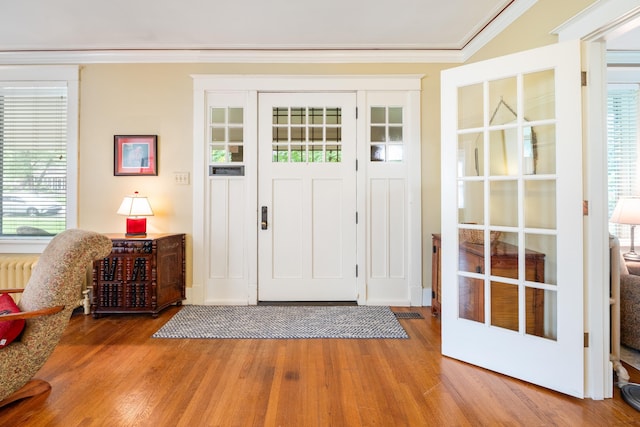 1668 Forest Ave, Memphis, TN 38112 - entryway with wood finished floors, crown molding, and radiator