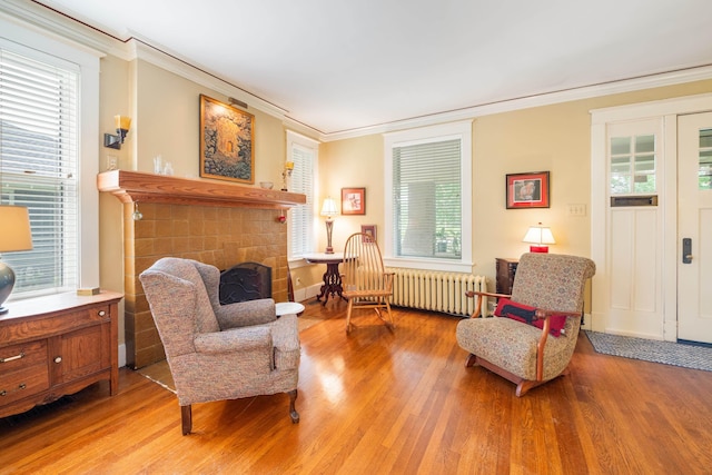 1668 Forest Ave, Memphis, TN 38112 - sitting room featuring radiator heating unit, ornamental molding, wood finished floors, and plenty of natural light