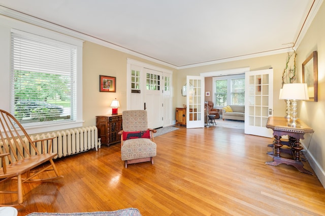 1668 Forest Ave, Memphis, TN 38112 - sitting room featuring radiator heating unit, french doors, light wood-style flooring, and crown molding