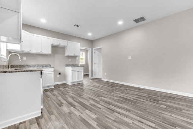 764 Garland St, Memphis, TN 38107 - kitchen featuring white cabinetry, light wood-type flooring, light stone countertops, and recessed lighting