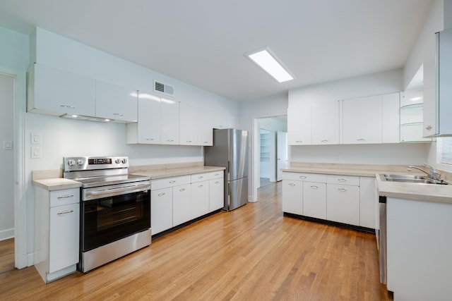5208 Gwynne Rd, Memphis, TN 38117 - kitchen featuring appliances with stainless steel finishes, light wood-type flooring, light countertops, and white cabinets