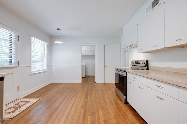 5208 Gwynne Rd, Memphis, TN 38117 - kitchen featuring stainless steel range with electric stovetop, light wood finished floors, light countertops, white cabinetry, and pendant lighting