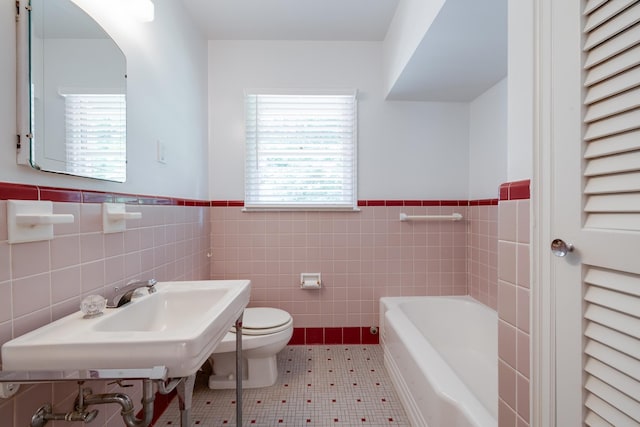 5208 Gwynne Rd, Memphis, TN 38117 - bathroom featuring plenty of natural light, a wainscoted wall, a garden tub, and tile walls