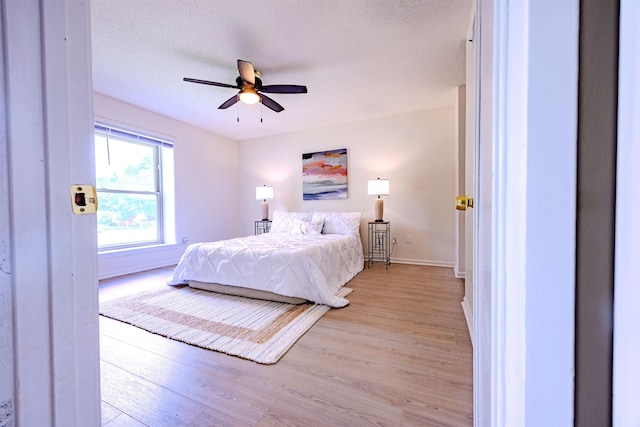 4447 Ross Rd, Memphis, TN 38141 - bedroom with light wood-type flooring, ceiling fan, and a textured ceiling