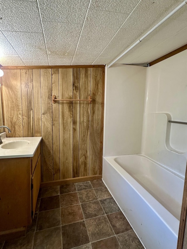 312 Pharr Ave, Selmer, TN 38375 - full bath featuring wooden walls, vanity, and bathtub / shower combination