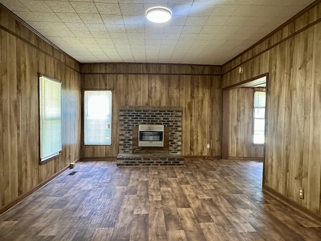 312 Pharr Ave, Selmer, TN 38375 - unfurnished living room featuring heating unit, wood walls, dark wood-type flooring, and a brick fireplace