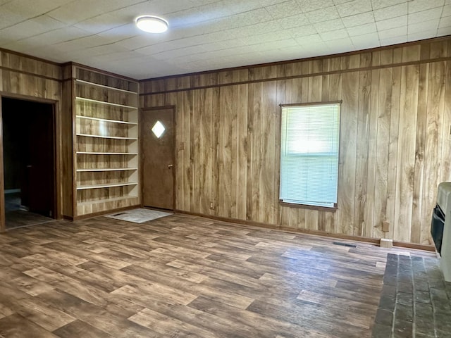 312 Pharr Ave, Selmer, TN 38375 - unfurnished living room featuring wood walls and wood finished floors