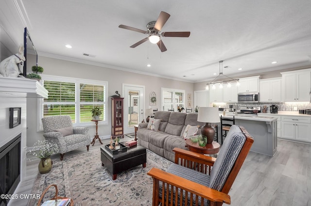 571 Todd Ray Cv, Henderson, TN 38340 - living room with plenty of natural light, ceiling fan, light wood finished floors, a fireplace, and ornamental molding