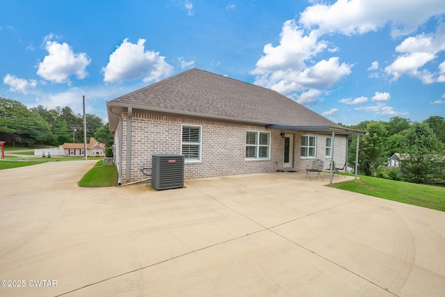 571 Todd Ray Cv, Henderson, TN 38340 - rear view of property with brick siding, roof with shingles, a patio area, and a yard
