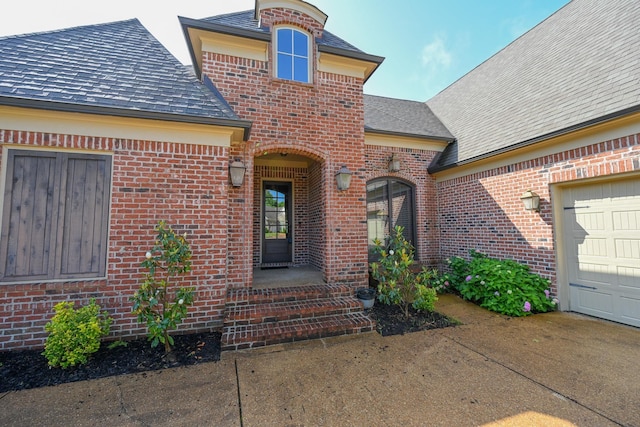 4342 Robinson Loop, Olive Branch, MS 38654 - entrance to property featuring a shingled roof, brick siding, an attached garage, and concrete driveway