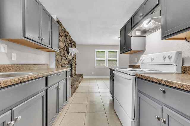 1017 Creston Ave, Memphis, TN 38127 - kitchen with white electric range, ventilation hood, gray cabinetry, and light tile patterned flooring