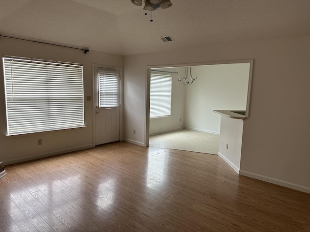 992 Zenith Cv N, Unicorp/Memphis, TN 38018 - spare room featuring a chandelier, wood finished floors, a textured ceiling, and a ceiling fan