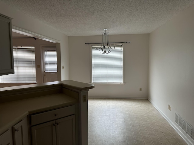 992 Zenith Cv N, Unicorp/Memphis, TN 38018 - unfurnished dining area featuring a chandelier and a textured ceiling