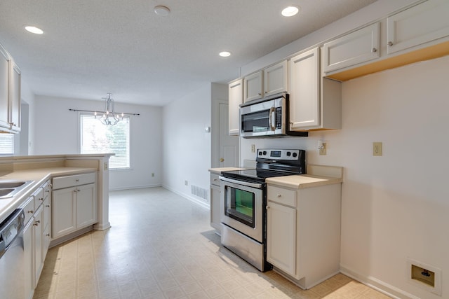 992 Zenith Cv N, Unicorp/Memphis, TN 38018 - kitchen featuring appliances with stainless steel finishes, light countertops, a chandelier, light flooring, and recessed lighting