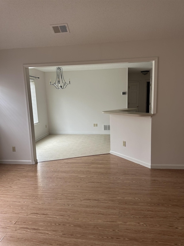 992 Zenith Cv N, Unicorp/Memphis, TN 38018 - spare room with wood finished floors, a chandelier, and a textured ceiling