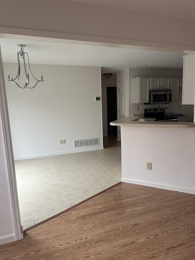992 Zenith Cv N, Unicorp/Memphis, TN 38018 - kitchen featuring stainless steel appliances, light wood-style flooring, a chandelier, and a peninsula