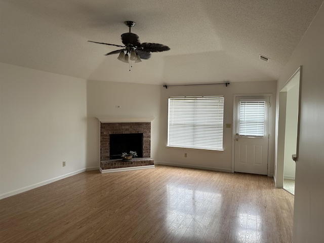 992 Zenith Cv N, Unicorp/Memphis, TN 38018 - unfurnished living room with a ceiling fan, wood finished floors, a textured ceiling, a fireplace, and vaulted ceiling