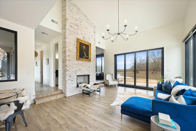 2270 Price Rd, Moscow, TN 38057 - living area with high vaulted ceiling, a chandelier, light wood-style flooring, and a fireplace