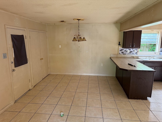 3612 Edgefield Dr, Memphis, TN 38128 - kitchen featuring tile counters, a textured ceiling, light tile patterned floors, dark brown cabinets, and tasteful backsplash