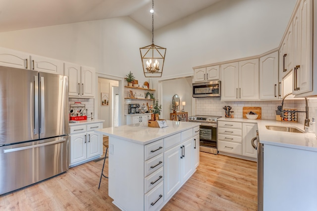 4950 Yum Yum Rd, Somerville, TN 38068 - kitchen with appliances with stainless steel finishes, a chandelier, a kitchen island, light wood-style flooring, and light countertops
