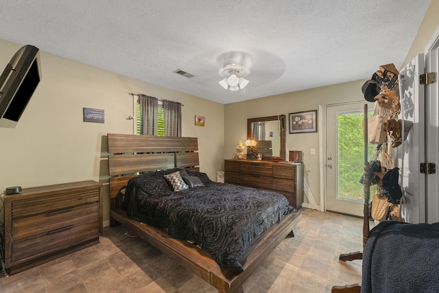 1635 Norton Rd, Middleton, TN 38052 - bedroom featuring access to outside, multiple windows, a textured ceiling, and stone finish floors
