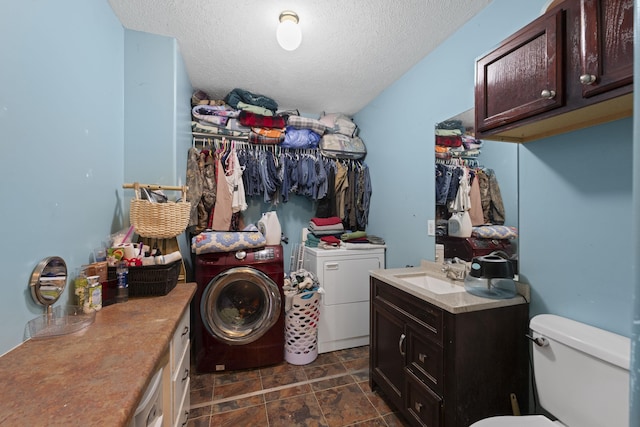 1635 Norton Rd, Middleton, TN 38052 - washroom with washer and clothes dryer, a textured ceiling, and dark stone finish floors