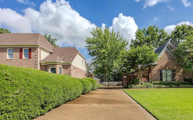 8799 Featherleigh Ln, Germantown, TN 38138 - view of front facade featuring brick siding, a front yard, a gate, and roof with shingles