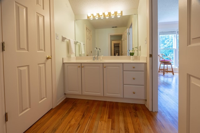8799 Featherleigh Ln, Germantown, TN 38138 - bathroom featuring wood finished floors, vanity, and a textured ceiling