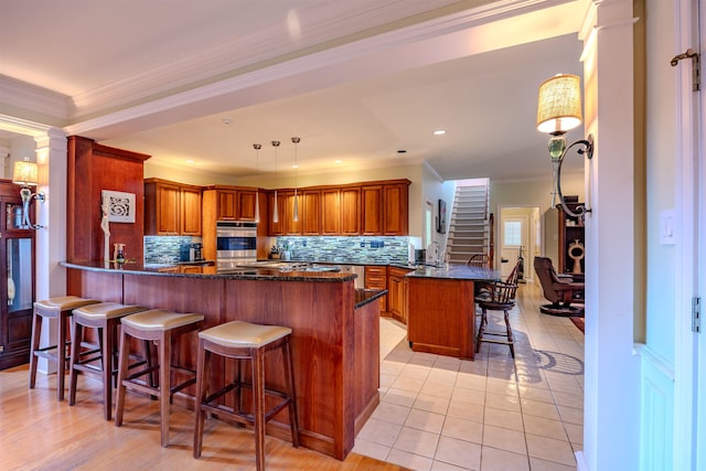 8799 Featherleigh Ln, Germantown, TN 38138 - kitchen with a peninsula, a kitchen bar, decorative backsplash, brown cabinets, and ornamental molding