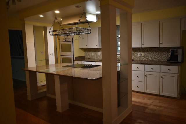101 Bob St, Selmer, TN 38375 - kitchen with double oven, wood finished floors, tasteful backsplash, white cabinets, and recessed lighting