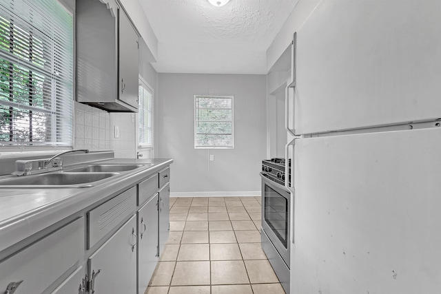 3205 E Shirley Cir, Memphis, TN 38127 - kitchen featuring freestanding refrigerator, stainless steel gas range, a textured ceiling, light tile patterned floors, and light countertops