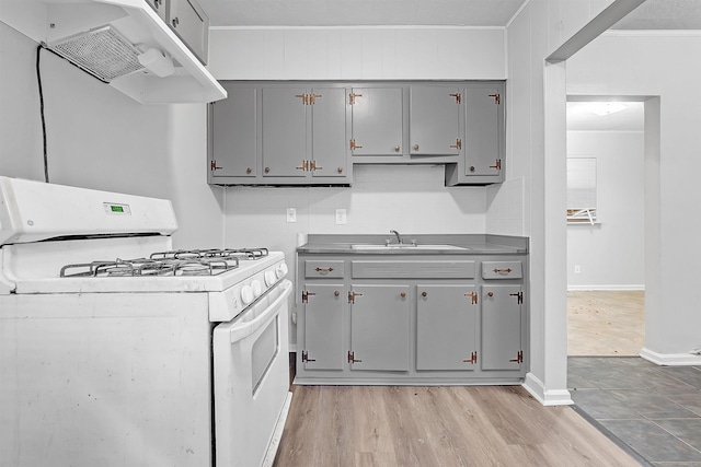 3205 E Shirley Cir, Memphis, TN 38127 - kitchen featuring white gas range, gray cabinetry, exhaust hood, crown molding, and light wood-style flooring