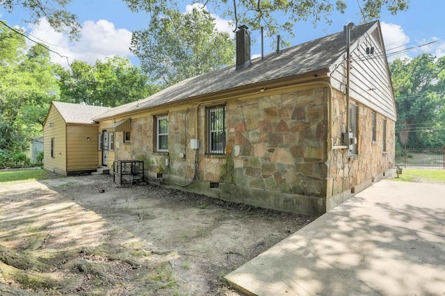3257 Millington Rd, Memphis, TN 38127 - back of property with stone siding, a chimney, crawl space, and a shingled roof