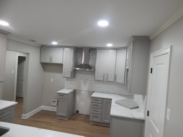 1849 Townsend Ave, Memphis, TN 38127 - kitchen with wall chimney range hood, gray cabinetry, crown molding, decorative backsplash, and dark wood finished floors