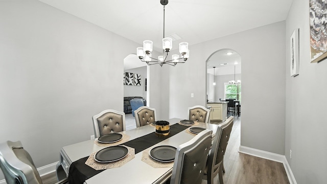 720 Woodland Fox Cv, Cordova, TN 38018 - dining room featuring a chandelier, arched walkways, and wood finished floors