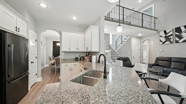 720 Woodland Fox Cv, Cordova, TN 38018 - kitchen with freestanding refrigerator, arched walkways, open floor plan, light stone countertops, and recessed lighting
