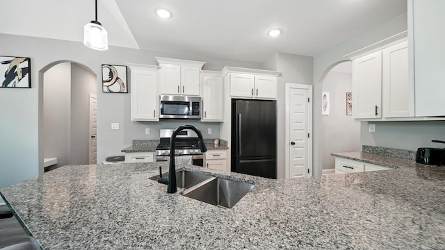 720 Woodland Fox Cv, Cordova, TN 38018 - kitchen featuring stainless steel appliances, arched walkways, dark stone counters, white cabinets, and recessed lighting