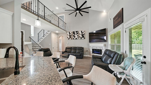 720 Woodland Fox Cv, Cordova, TN 38018 - living area with arched walkways, a glass covered fireplace, high vaulted ceiling, stairway, and wood finished floors