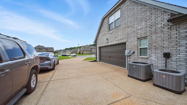 720 Woodland Fox Cv, Cordova, TN 38018 - view of side of home with concrete driveway, a garage, a residential view, and brick siding