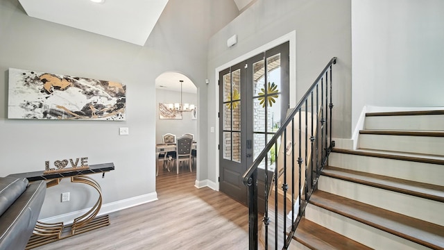 720 Woodland Fox Cv, Cordova, TN 38018 - foyer featuring wood finished floors, a chandelier, stairway, arched walkways, and a towering ceiling