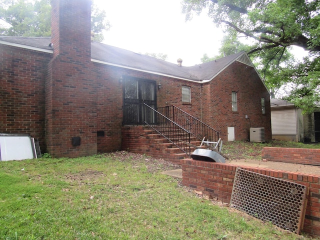 4632 Plato Ave, Memphis, TN 38128 - back of house featuring brick siding, a chimney, and a lawn