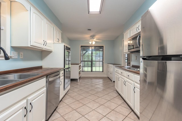 2539 Kenwood Rd, Bartlett, TN 38134 - kitchen with stainless steel appliances, white cabinets, light tile patterned floors, and a ceiling fan