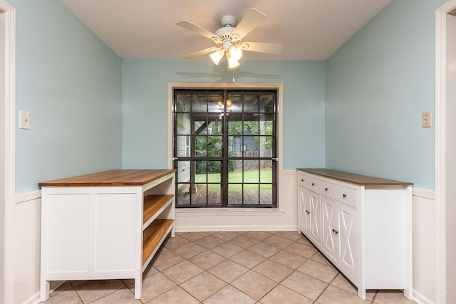 2539 Kenwood Rd, Bartlett, TN 38134 - doorway to outside with a wainscoted wall, light tile patterned floors, a ceiling fan, and a textured ceiling
