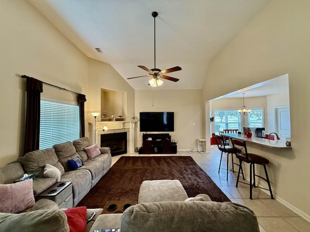 6632 W Thriveaway Cv, Bartlett, TN 38135 - living area featuring light tile patterned floors, a tiled fireplace, high vaulted ceiling, a chandelier, and a ceiling fan