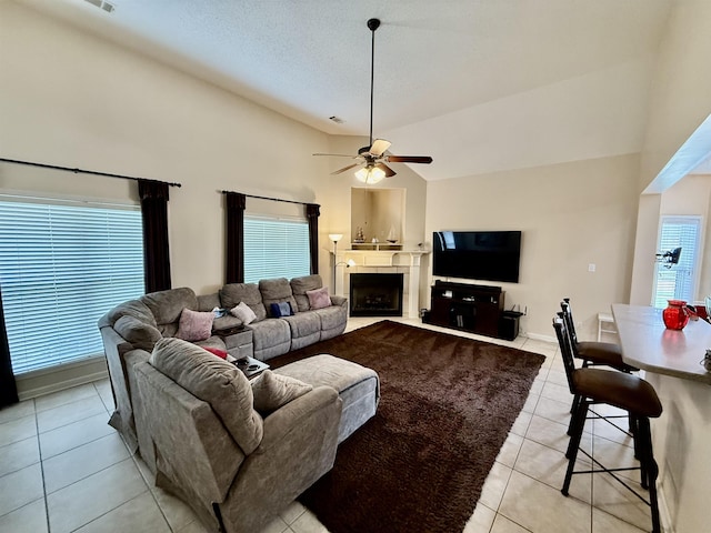 6632 W Thriveaway Cv, Bartlett, TN 38135 - living room with light tile patterned floors, ceiling fan, a tiled fireplace, and high vaulted ceiling