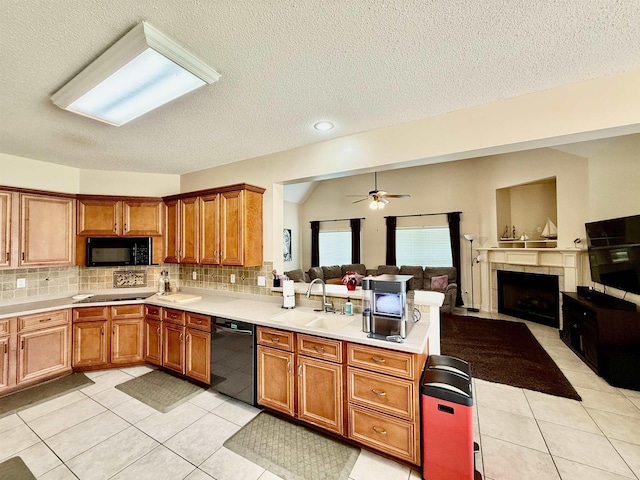 6632 W Thriveaway Cv, Bartlett, TN 38135 - kitchen featuring black appliances, a peninsula, brown cabinetry, open floor plan, and a textured ceiling