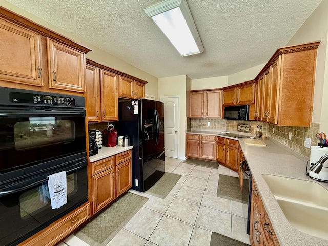 6632 W Thriveaway Cv, Bartlett, TN 38135 - kitchen with black appliances, light countertops, brown cabinetry, and a textured ceiling