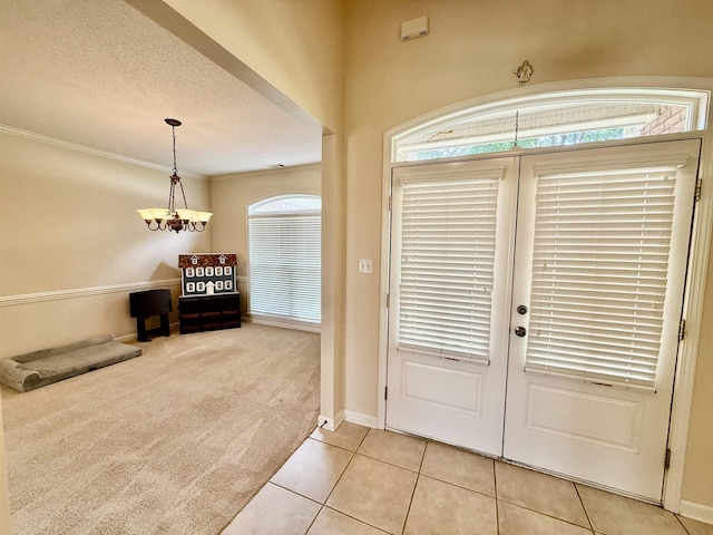 6632 W Thriveaway Cv, Bartlett, TN 38135 - foyer featuring light tile patterned floors, a chandelier, light colored carpet, a textured ceiling, and french doors
