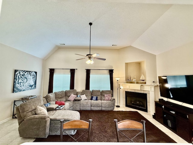 6632 W Thriveaway Cv, Bartlett, TN 38135 - living area featuring light tile patterned floors, vaulted ceiling, ceiling fan, a tiled fireplace, and a textured ceiling