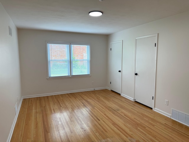 3652 Acacia St, Memphis, TN 38116 - unfurnished bedroom featuring light wood-style flooring and two closets